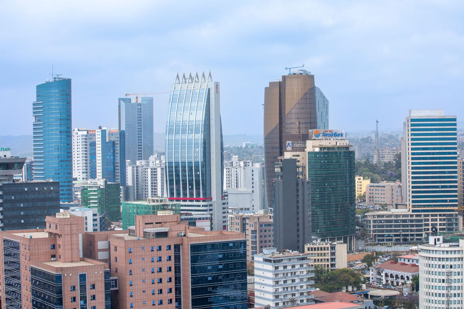 Office towers and high-rise buildings in central Addis Ababa under a cloudy sky.