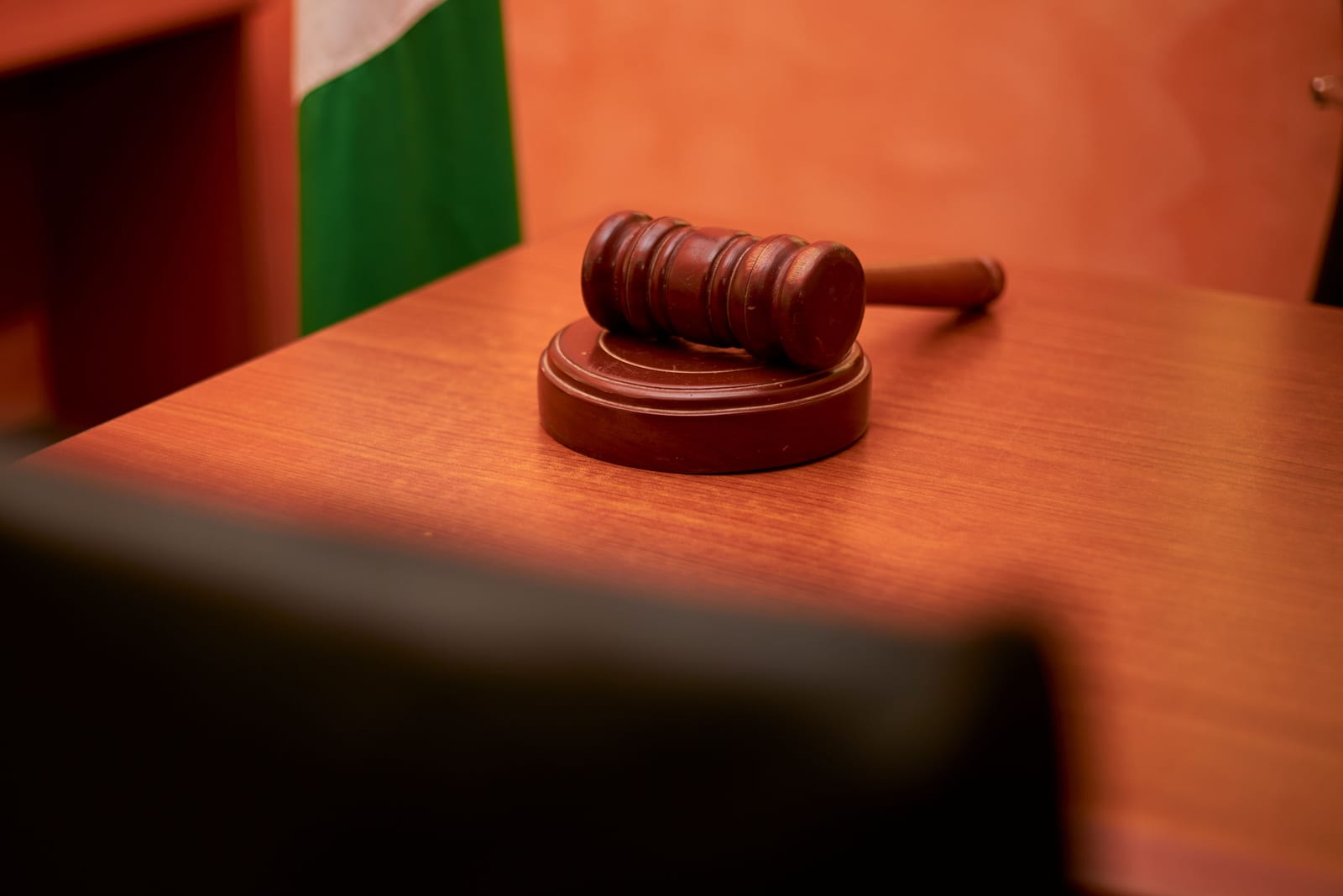 A judge's gavel on a wooden desk in a courtroom