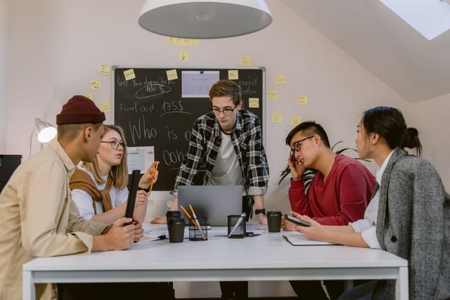 A small team working around a table with laptops and notes