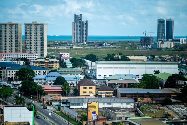Lagos seen from above, with high-rise towers and the Atlantic on the horizon