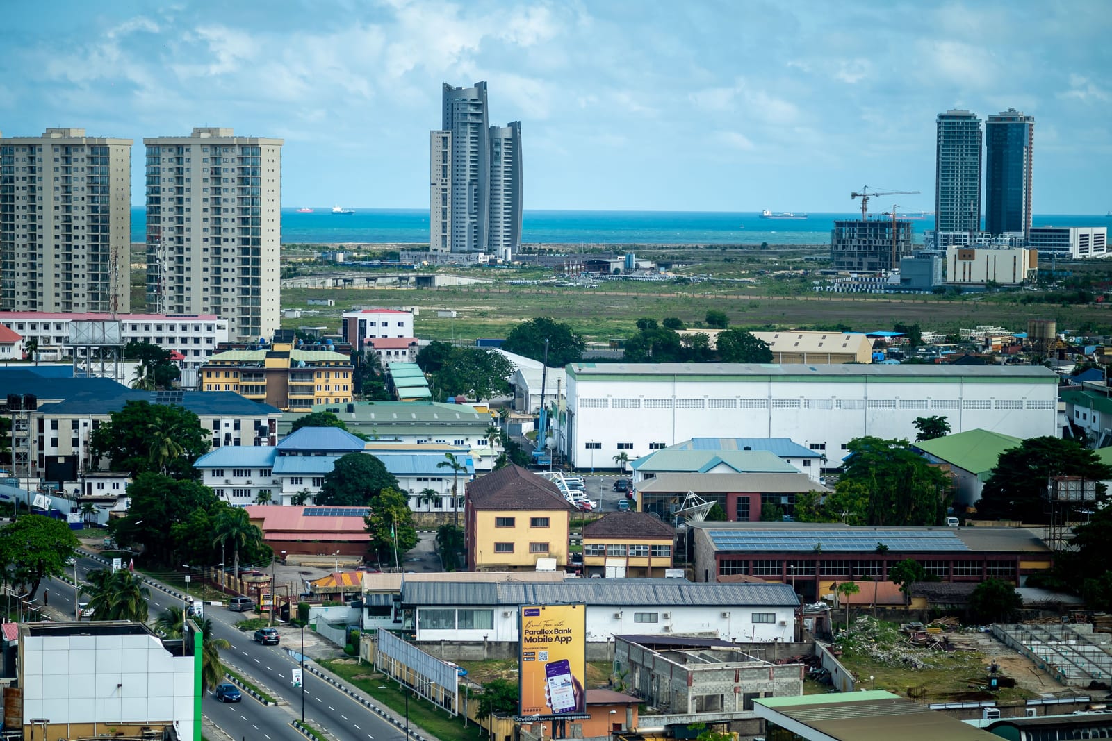 Lagos seen from above, with high-rise towers and the Atlantic on the horizon