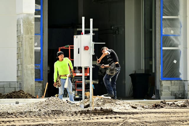 Construction workers installing equipment on a dug-up city street