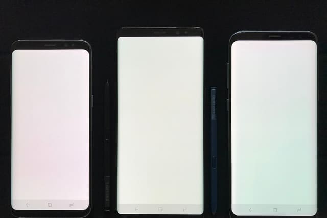 Three smartphones with their screens on