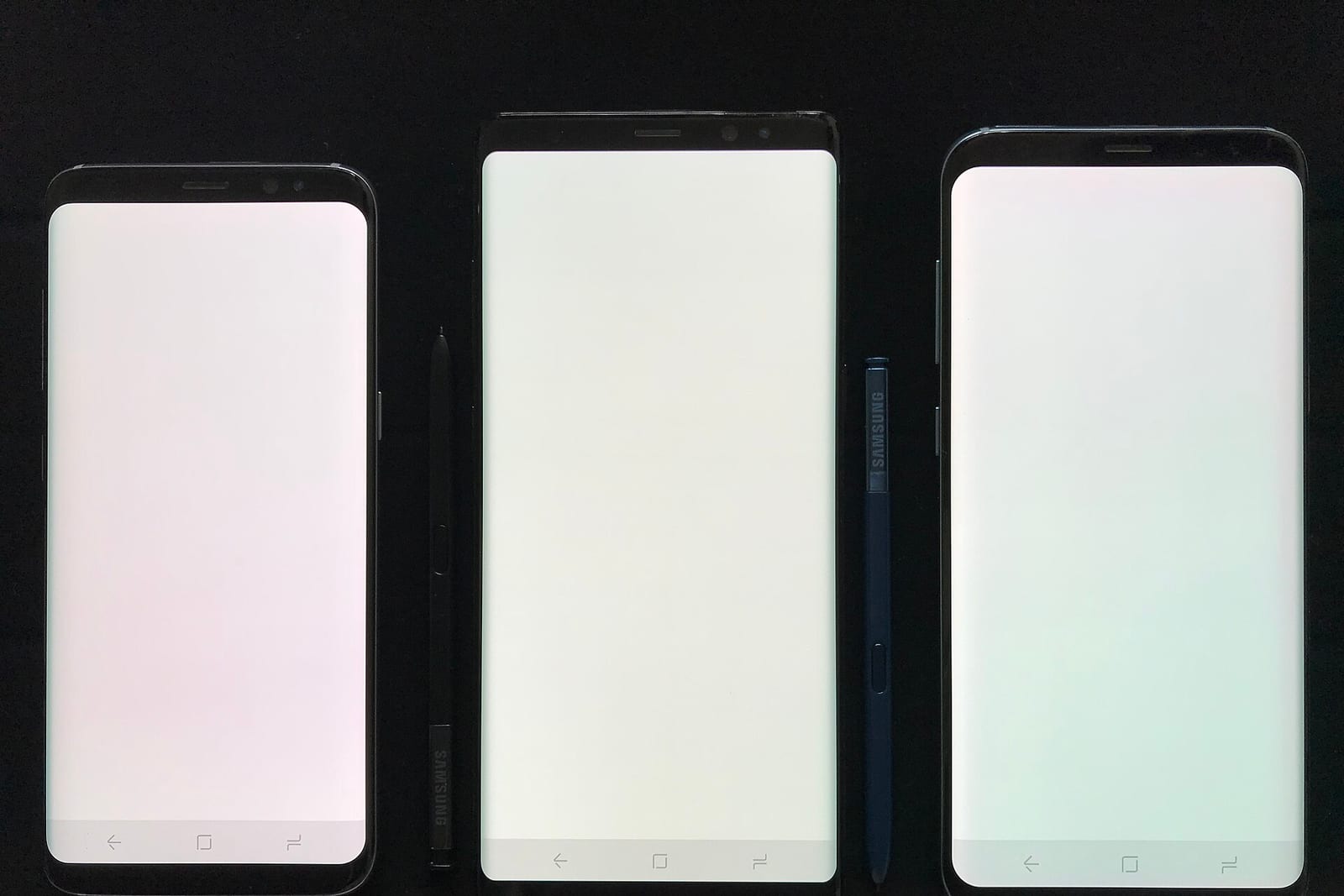 Three smartphones with their screens on