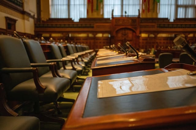 Empty desks and microphones in a council chamber