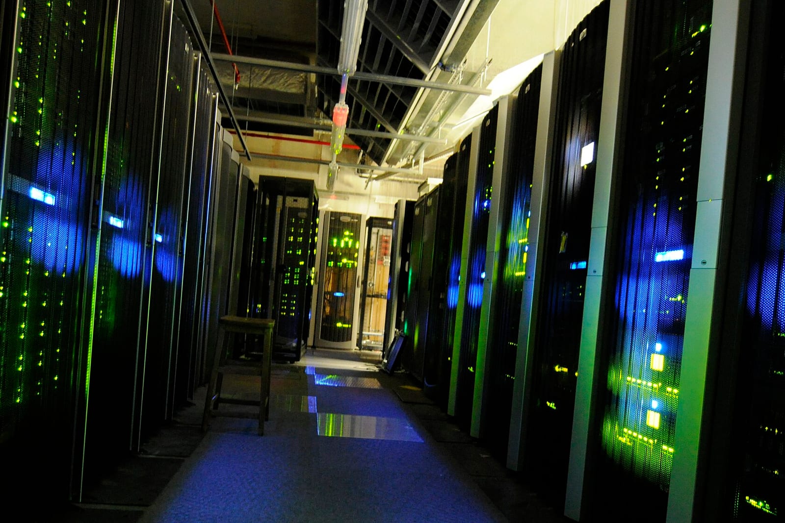 Racks of servers lit in a dark server room