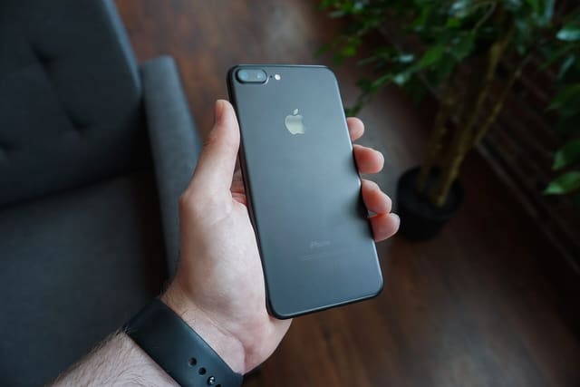 A hand holding a black smartphone