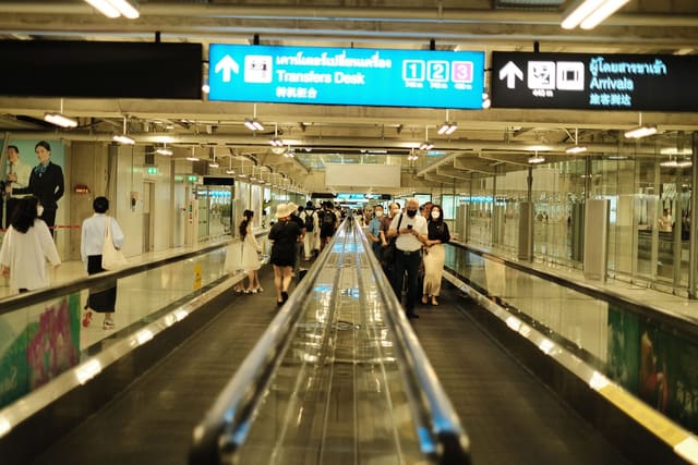 Travellers on a moving walkway in an airport terminal